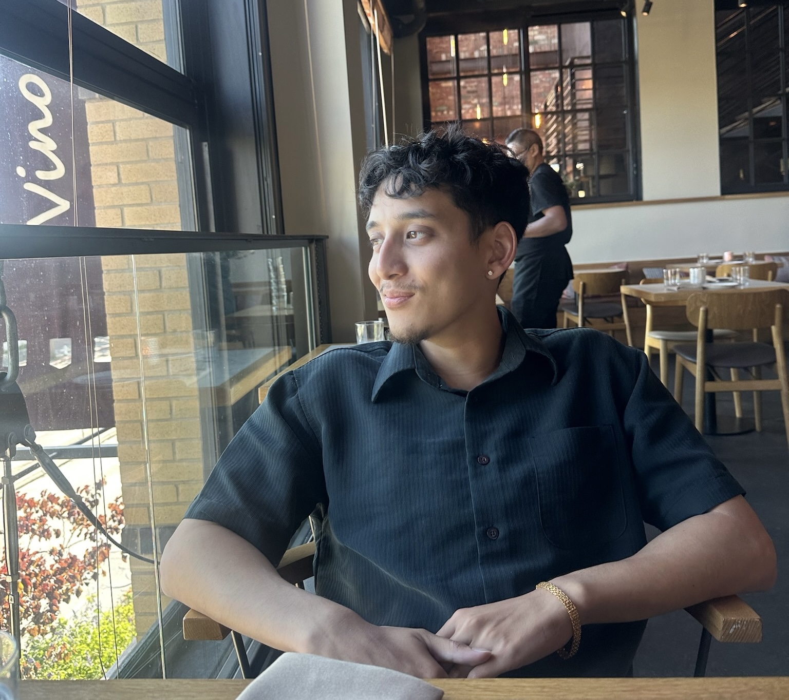 Sulav Rajbhandary seated beside a restaurant window